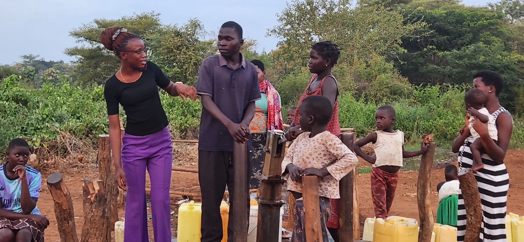 Community members gathered at a local water point during outreach.